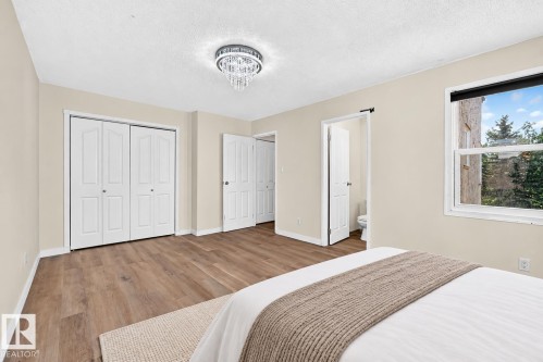 Wood-finish flooring throughout, bright window, and a contemporary chandelier - 161 Lancaster Terrace Nw, Edmonton, AB 