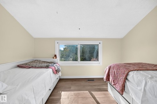 Room featuring wood-finish flooring, a window with white trim, and a built-in daybed with storage drawers - 161 Lancaster Terrace Nw, Edmonton, AB 