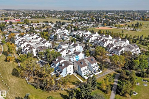 Townhouse community featuring multiple residential buildings, surrounding green spaces, and mature landscaping - 161 Lancaster Terrace Nw, Edmonton, AB 