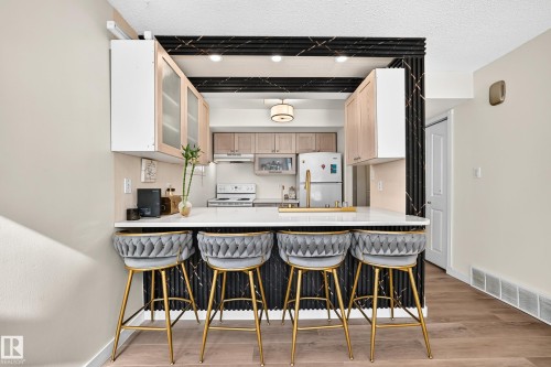 Breakfast bar with a white countertop, gold-finish faucet, and integrated sink - 161 Lancaster Terrace Nw, Edmonton, AB 
