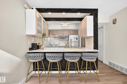 Breakfast bar with a white countertop, gold-finish faucet, and integrated sink - 