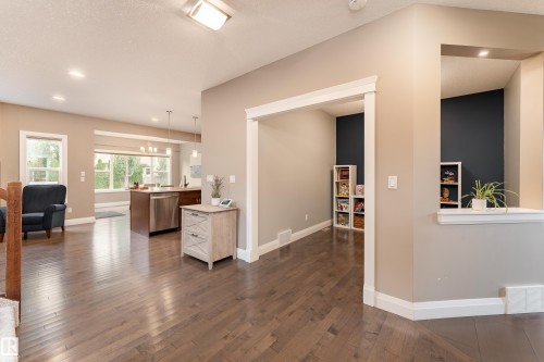 Hardwood flooring throughout, recessed ceiling lighting, kitchen island with stainless steel dishwasher, and a framed room opening - 6613 31 Avenue, Beaumont, AB 