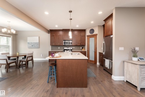 Hardwood-finish flooring, recessed lighting, and a kitchen island with pendant lighting - 6613 31 Avenue, Beaumont, AB 