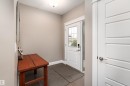 Entryway featuring a paneled door with glass inserts, transom window, and a sleek ceiling-mounted light fixture - 6613 31 Avenue, Beaumont, AB 
