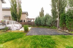 Expansive backyard featuring a manicured lawn, a wooden deck, and mature trees creating natural privacy - 