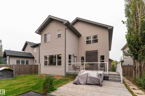 Exterior featuring light-toned horizontal siding, a multi-level deck, and a privacy fence - 6613 31 Avenue, Beaumont, AB 