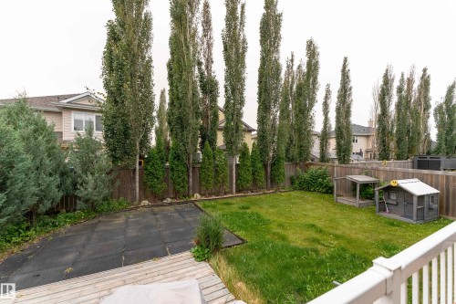Expansive backyard featuring a wood deck, lawn area, and privacy fencing - 6613 31 Avenue, Beaumont, AB 