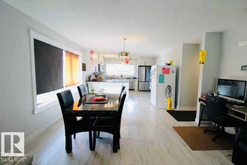 Open-concept layout with wood-finish flooring, white trim windows, and recessed lighting - 17440 77 Street Nw, Edmonton, AB 