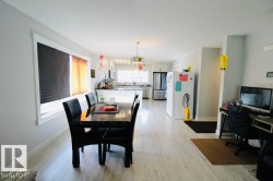 Open-concept layout with wood-finish flooring, white trim windows, and recessed lighting - 