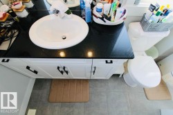 White vanity with dark hardware, black countertop, and integrated white sink - 