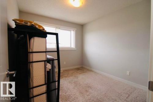 Carpeted flooring, neutral wall color, and a window with white trim - 17440 77 Street Nw, Edmonton, AB 