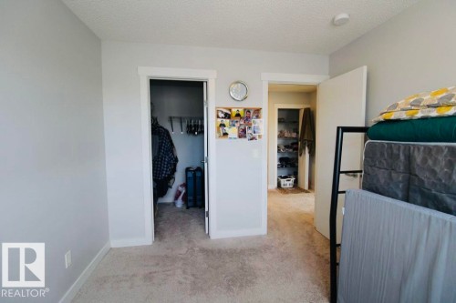 Textured ceiling, light-toned wall paint, white trim, and a built-in closet with shelving - 17440 77 Street Nw, Edmonton, AB 