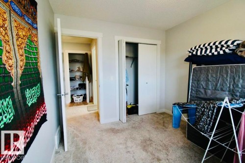Carpeted flooring, neutral wall color, white trim, and a built-in closet with sliding doors - 17440 77 Street Nw, Edmonton, AB 