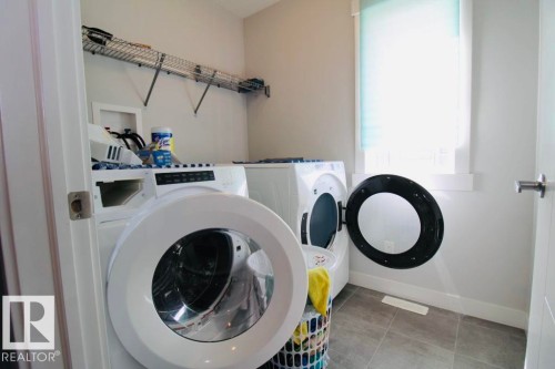 Laundry area with tile flooring and a built-in wire shelf - 17440 77 Street Nw, Edmonton, AB 
