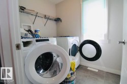 Laundry area with tile flooring and a built-in wire shelf - 