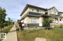Two-story residence featuring light and dark siding, a covered porch with stone detailing, and multiple windows - 17440 77 Street Nw, Edmonton, AB 