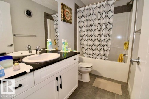 Dual sink vanity with black countertop and white cabinetry - 17440 77 Street Nw, Edmonton, AB 