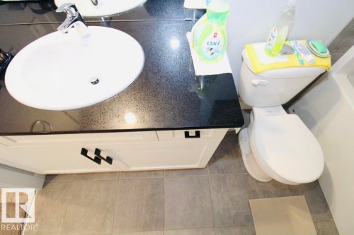 White vanity with dark countertop, integrated sink, and chrome faucet - 17440 77 Street Nw, Edmonton, AB 