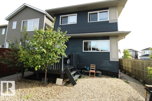 Two-story exterior with horizontal siding, multiple windows, and a raised wooden deck - 17440 77 Street Nw, Edmonton, AB 