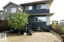 Two-story exterior with horizontal siding, multiple windows, and a raised wooden deck - 17440 77 Street Nw, Edmonton, AB 