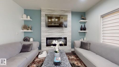 Fireplace featuring a modern insert, textured surround, and a flat-panel display - 1103 30 Street Nw, Edmonton, AB 