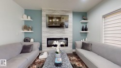 Fireplace featuring a modern insert, textured surround, and a flat-panel display - 