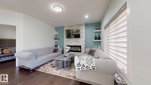 Wood-finish flooring, recessed lighting, built-in fireplace, wall-mounted shelving, and window blinds - 1103 30 Street Nw, Edmonton, AB 
