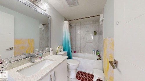 Vanity with a rectangular undermount sink, a chrome faucet, and a light-colored countertop - 1103 30 Street Nw, Edmonton, AB 