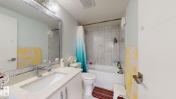 Vanity with a rectangular undermount sink, a chrome faucet, and a light-colored countertop - 