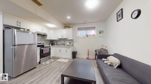 Full kitchen featuring white cabinetry, stainless steel appliances, and a tiled backsplash - 1103 30 Street Nw, Edmonton, AB 