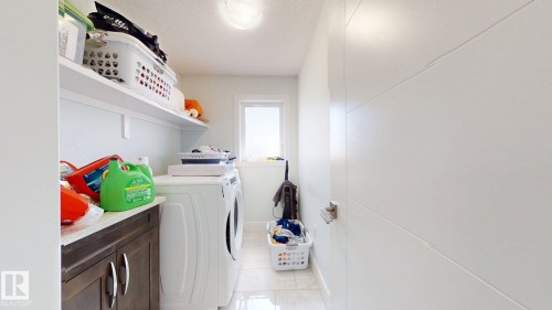 White panel door with horizontal detailing, built-in shelving, wood-finish cabinetry, and tiled flooring - 1103 30 Street Nw, Edmonton, AB 