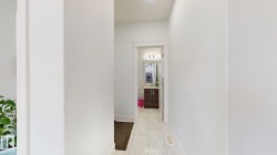 Hallway with light-toned walls and tile flooring - 