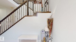 Staircase featuring dark wood-finish handrails, metal balusters, and white risers - 