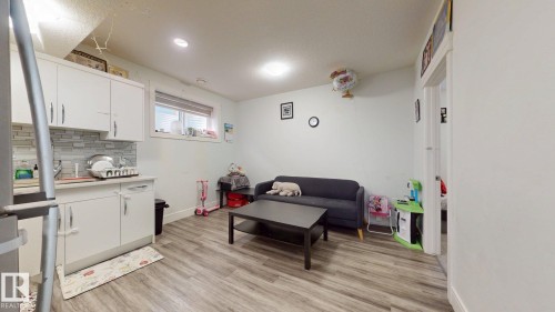 Kitchenette featuring white cabinetry, a subway tile backsplash, and a stainless steel sink - 1103 30 Street Nw, Edmonton, AB 