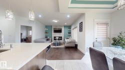 Kitchen island with a light-toned countertop, sink, and pendant lighting - 