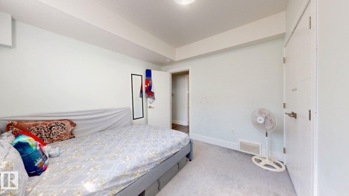 Carpeted flooring, white walls, white doors, and a built-in wall unit - 1103 30 Street Nw, Edmonton, AB 