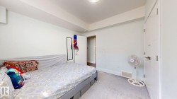 Carpeted flooring, white walls, white doors, and a built-in wall unit - 