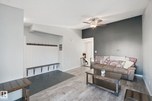 Vaulted ceiling with ceiling fan, wood-finish flooring, built-in coat rack, built-in bench seating, and accent wall - 38 Menalta Place, Cardiff, AB 