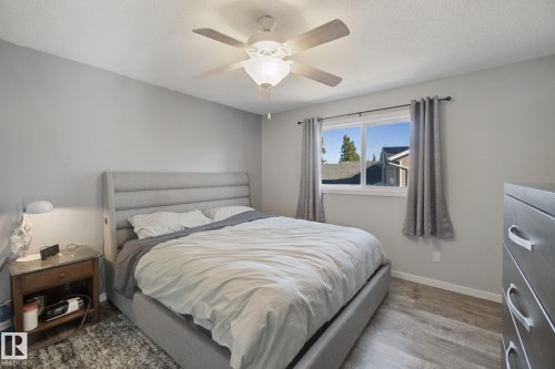 Recessed window with white trim, wood-finish flooring, ceiling fan with integrated lighting, light gray wall tones, and white ceiling - 38 Menalta Place, Cardiff, AB 