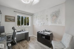 Wood-finish flooring, white trim window, neutral wall paint, and overhead lighting - 