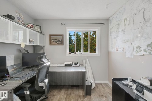 Wood-finish flooring with a multi-pane window, built-in cabinetry, and neutral wall tones - 38 Menalta Place, Cardiff, AB 