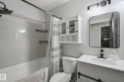 White vanity with integrated sink, black single-handle faucet, and rectangular mirror - 