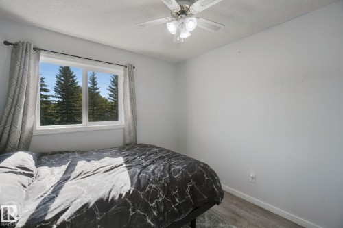 White walls, wood-finish flooring, and a ceiling fan with integrated lighting - 38 Menalta Place, Cardiff, AB 