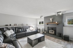 Painted brick fireplace with wood mantel and wood-burning insert - 