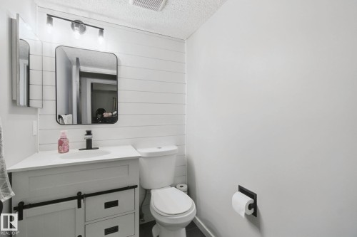 Vanity with barn door-style cabinetry, undermount sink, and matte black faucet - 38 Menalta Place, Cardiff, AB 