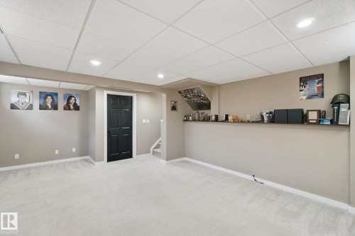 Recessed lighting, light-toned carpeting, black paneled door, built-in shelving, and drop ceiling - 38 Menalta Place, Cardiff, AB 
