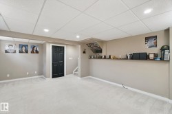Recessed lighting, light-toned carpeting, black paneled door, built-in shelving, and drop ceiling - 