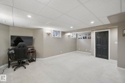 Recessed lighting with sconce accents, neutral wall color, light-toned carpet flooring, drop ceiling, and a dark paneled door - 