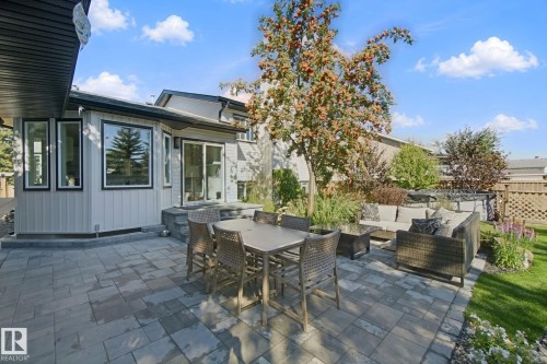 Paver patio with an elevated section, featuring mature trees and established landscaping - 38 Menalta Place, Cardiff, AB 