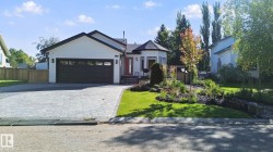 Contemporary exterior with white siding, dark trim, and a prominent dark garage door - 